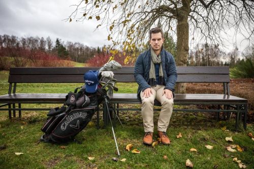 Lukáš Tintěra sedí na lavičce v přírodě, má vedle sebe golfové vybavení