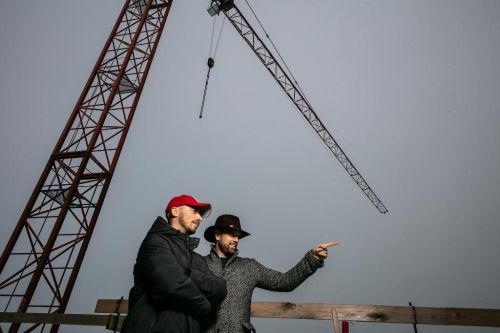 Martin Hubinger a Petr Teplý stojí na stavbě, nad nimi je jeřáb