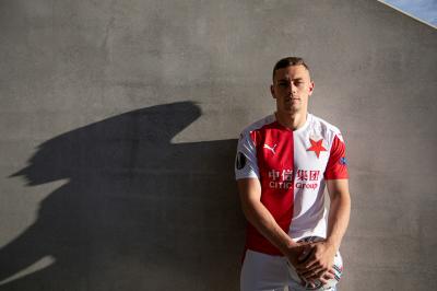 Tomáš Holeš stojí u zdi ve fotbalovém dresu Slavie, drží v rukou míč