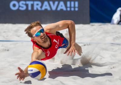 Ondřej Perušič skáče po volejbalovém míči na beachvolejbalovém hřišti