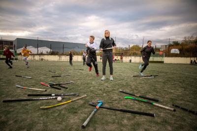 Kateřina Laciná s dětmi při tréninku pozemního hokeje s hokejkami