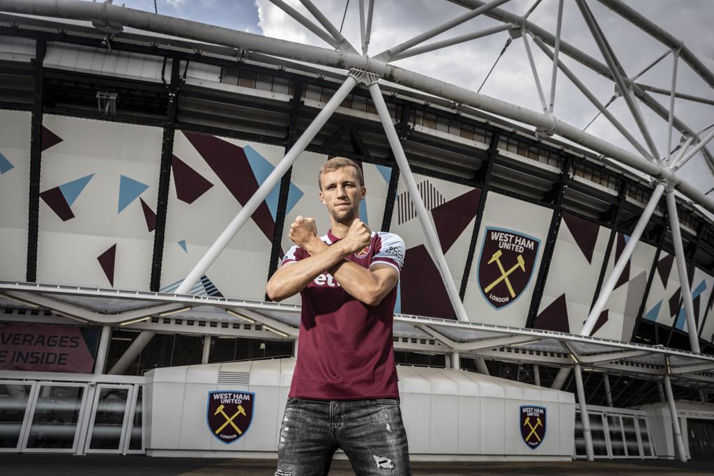 Tomáš Souček s gestem West hamu před londýnským stadionem.