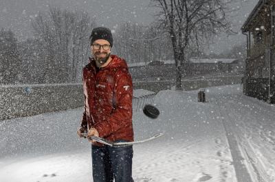 Michal Handzuš s hokejkou a pukem na sněhu, sněží