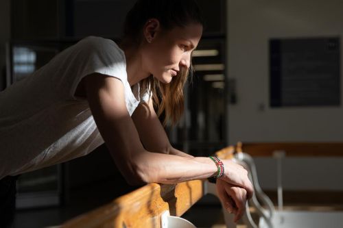 Marcela Joglová ozářená sluncem opřená o lavičku v tělocvičně.